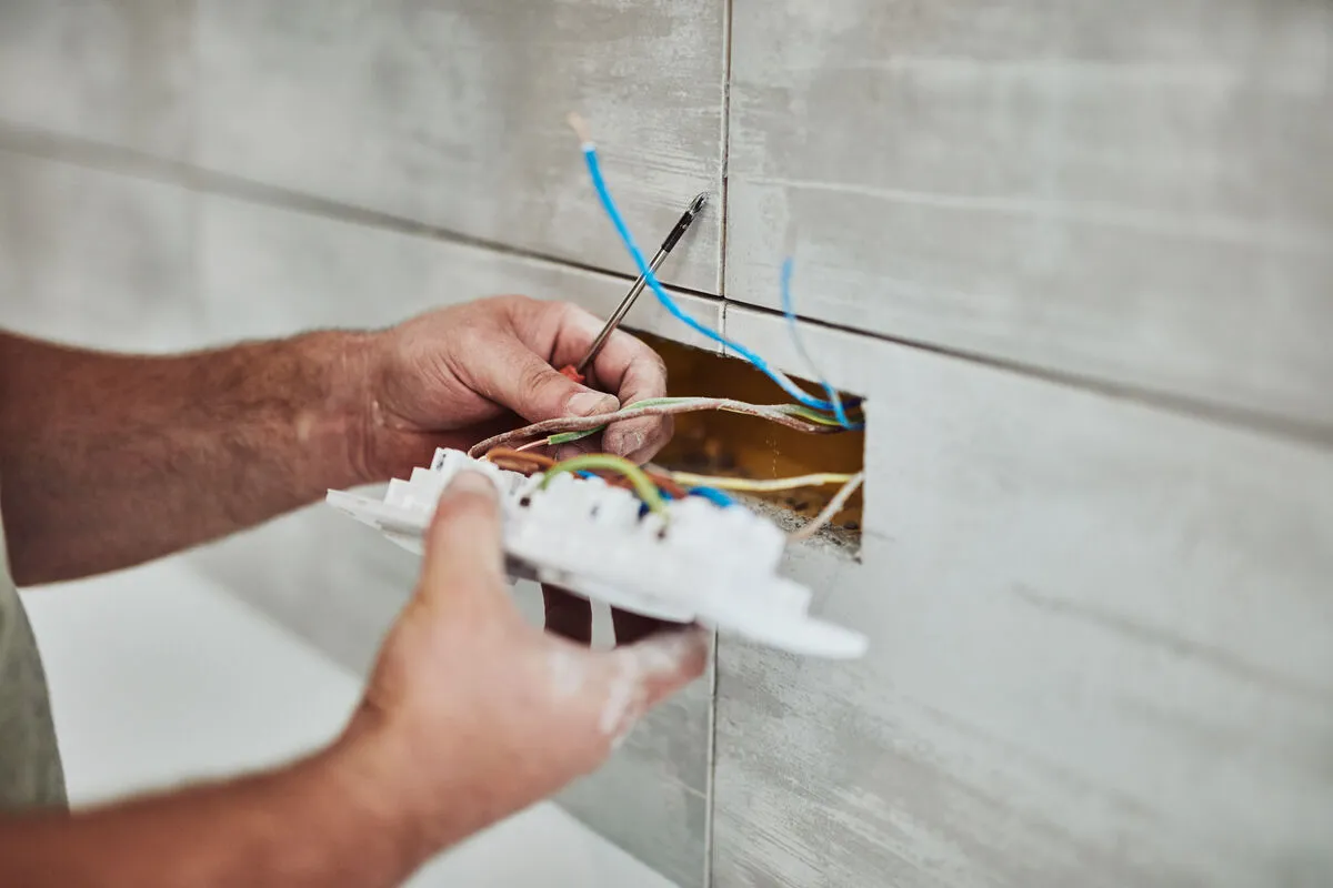 Electrician performing maintenance on electrical wiring